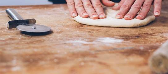 Woman hands kneading dough on the table