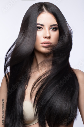 Photo Beautiful brunette girl in move with a perfectly smooth hair, and classic make-up