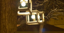 Modern Lantern Hang On Trees In Front Of A Restaurant In A Cold Late Winter Night.