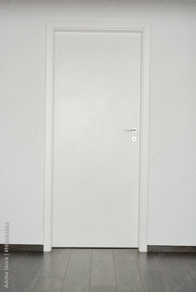 White closed door with silver doorknob on white wall background and parquet floor - obrazy, fototapety, plakaty 