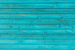 Section of textured turquoise wood panelling from a seaside beach hut. Could be used as a background to illustrate beach and summer holiday themes.

