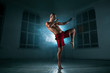 The young man kickboxing in blue smoke