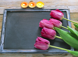 Wall Mural - Fresh colorful tulips over wooden blackboard for copy space and