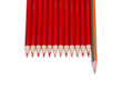 Black pencil standing out from the red pencils, isolated