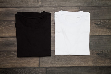 White and black blank t-shirt on wooden background