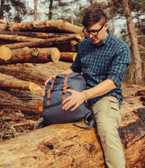 Wall Mural - Backpacker sitting on wood trunk