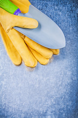 Yellow safety gloves metal hand shovel on metallic background ga