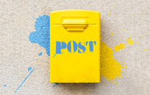 Yellow Post Office Mailbox On Plastered Wall