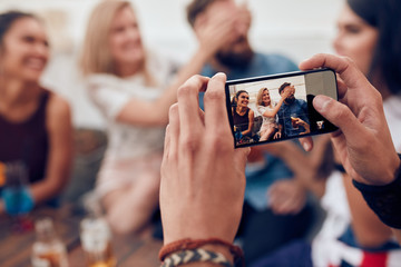 Wall Mural - Photographing friends at party with mobile phone