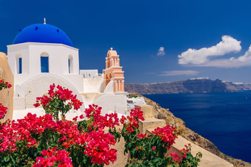 Wall Mural - Bougainvillea bloom around blue domed church of Agios Dimitrios in Oia, Santorini