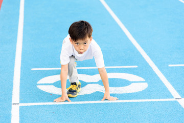 Boy runnin on blue track