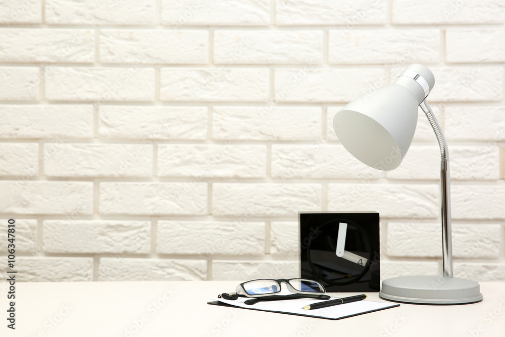 Lamp and home decor on brick wall background
