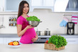 © Africa Studio - Pregnant woman with colander of fresh lettuce in the kitchen