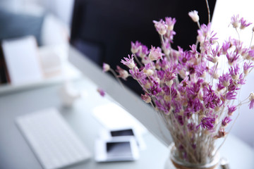 Sticker - Modern interior. Comfortable workplace. Wooden table with beautiful bouquet of flowers and computer on it, close up