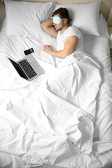 Wall Mural - Young man sleeping with blindfold in bed at home