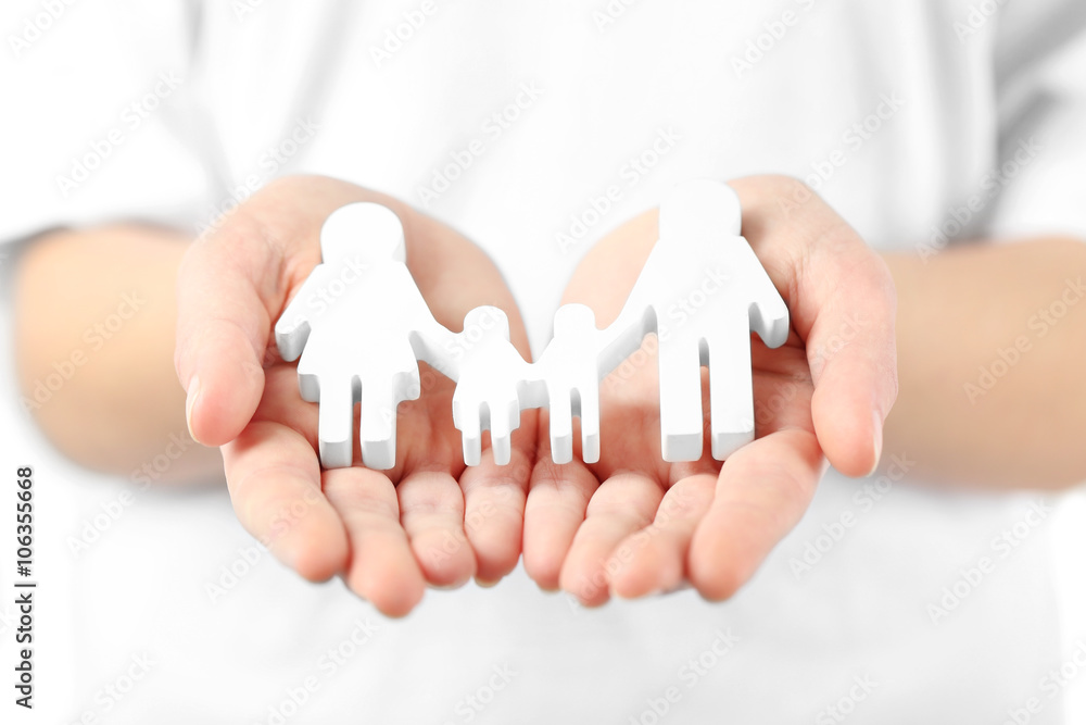 Female hands holding family figure, close up