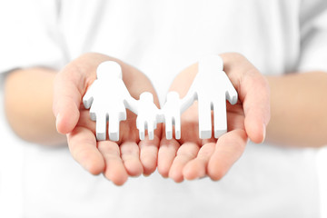 Wall Mural - Female hands holding family figure, close up