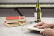 © RCH Photographic - Person reading at table with a glass of wine