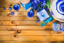 Spa Concept In Blue Tones On A Wooden Surface: Candle, Sea Salt, Flowers, Soaps, Essential Oils. Top View.