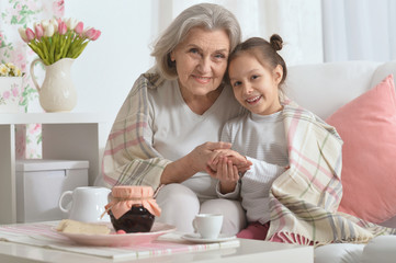 Wall Mural - Senior woman with granddaughter with tea