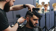 © Nigrechok - Male barber combing and shaving hair of a male client