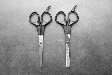 Sticker - Professional scissors with black handles on a dark grey surface, top view