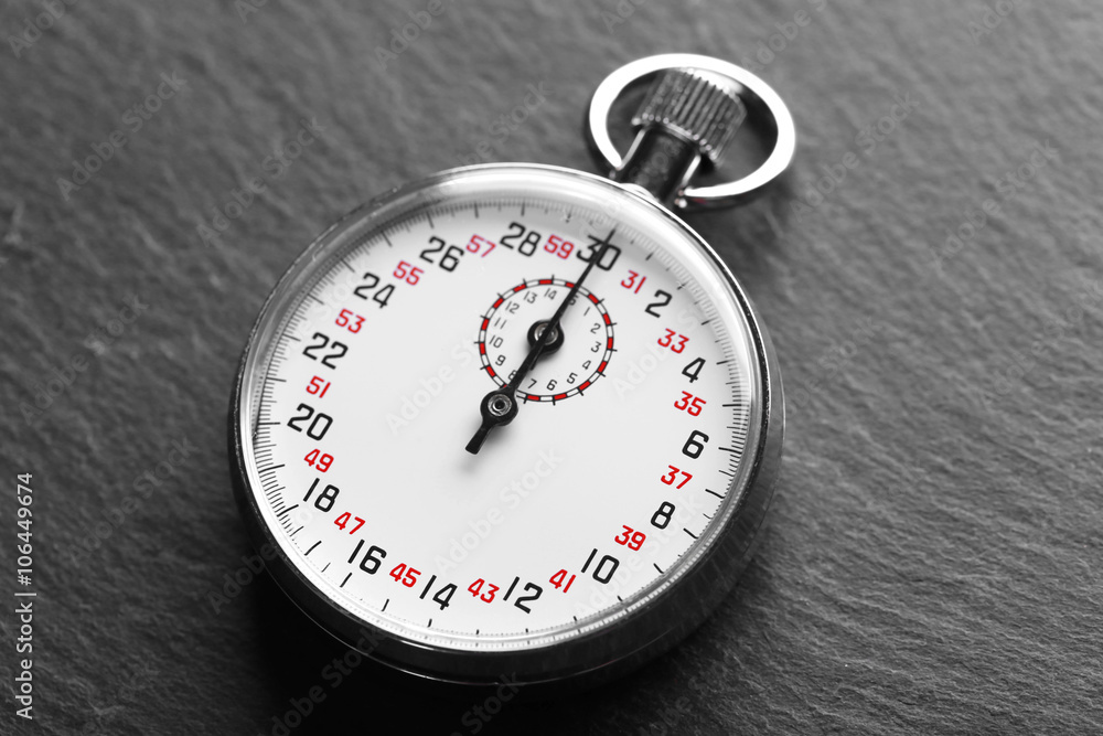Stopwatch on black textured background, close up