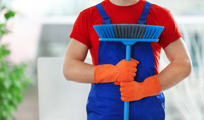 Wall Mural - Young janitor holding floor brush in office