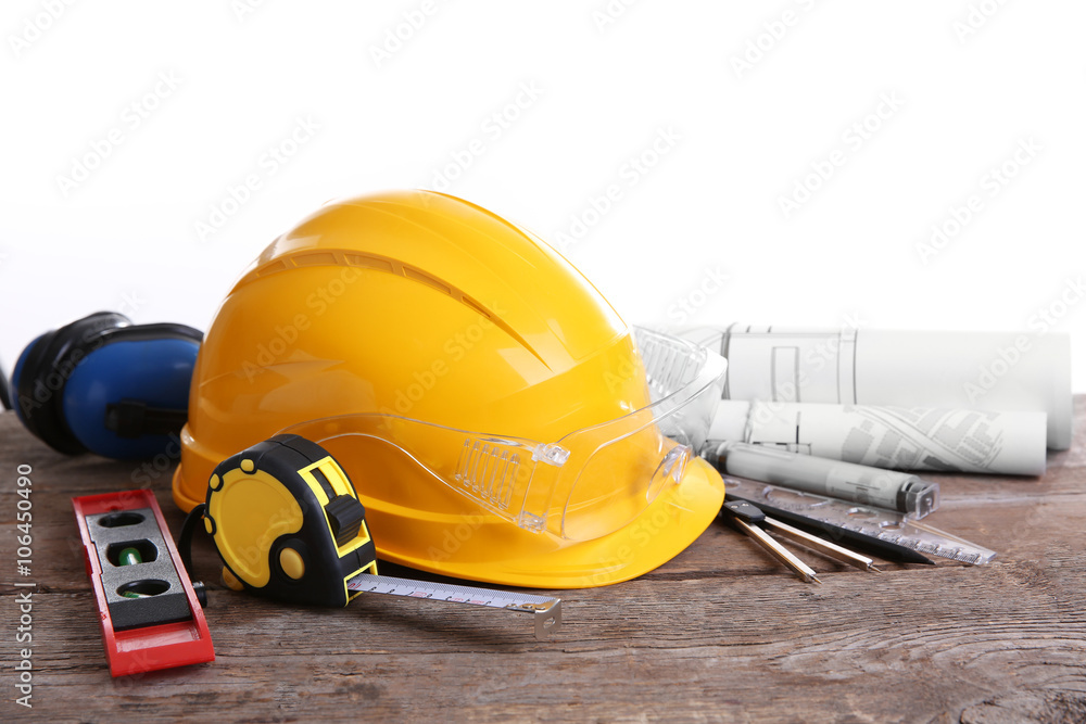 Yellow helmet and blueprint on a white background.