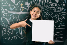 Smart Little Girl Smiling In Front Of A Blackboard