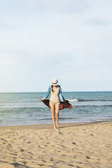 Wall Mural - Woman walking away on the idylic beach.