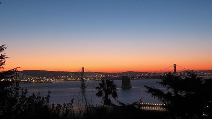 Fototapete - Time-lapse of San Francisco-Oakland Bay Bridge lights at sunrise