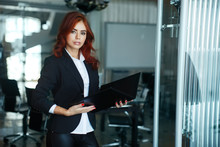 Young Beautiful Business Girl Standing In Office And Holding A Folder For Documents