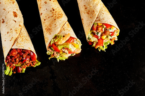 Fotografía Trio of Tex Mex Fajita Wraps on Black Background