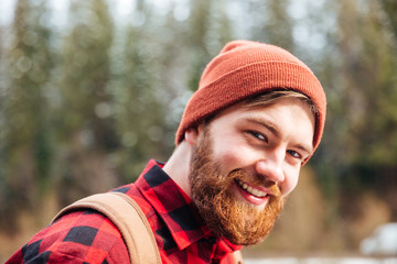 Poster - Happy man with beard in hat and checkered shirt outdoors