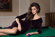 © Dmitri Strakhov - gorgeous woman brunette wears luxury evening dress lying on the pool table