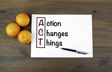 Wall Mural - Wooden background with oranges and text: Action Changes Things (