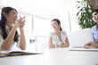 © Monet - Young women have a discussion in a stylish office