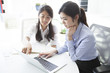 © Monet - Two business women looking at a laptop together