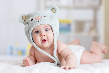 5 months baby girl weared in funny hat lying down on a blanket