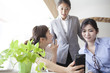 © Monet - Three of the women, looking at a smartphone together in the office