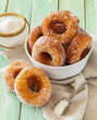 Homemade sugared cronuts in a bowl on a worn out wooden table