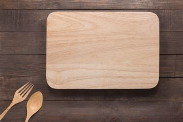 Wall Mural - Cutting board, spoon and fork on the wooden background