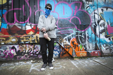 Caucasian Teenage Boy Standing By Graffiti Wall