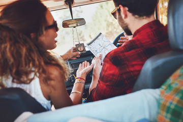 Couple using map on a roadtrip to decide which way to go