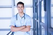 © WavebreakMediaMicro - Happy male doctor standing with arms crossed