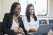 © Inti St Clair/Blend Images - Businesswomen using laptop on train