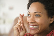 © JGI/Jamie Grill/Blend Images - Close up of Black woman smiling with fingers crossed