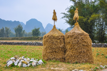 Two haystacks in the background of mountains and bamboo