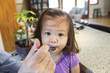 © Sam Diephuis/Blend Images - Father feeding daughter in kitchen